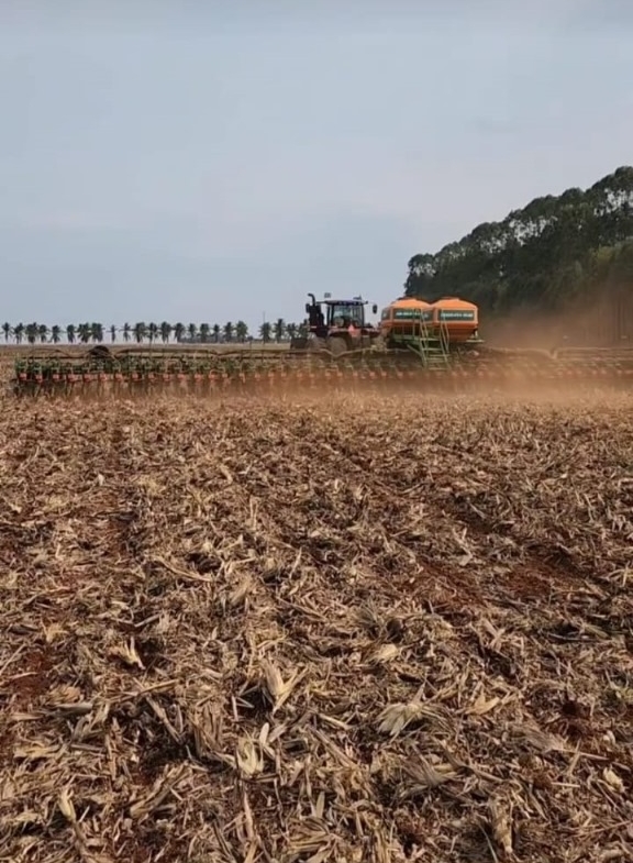 Foto de um trator plantando milho em uma fazenda na cidade de Campos de Júlio - MT